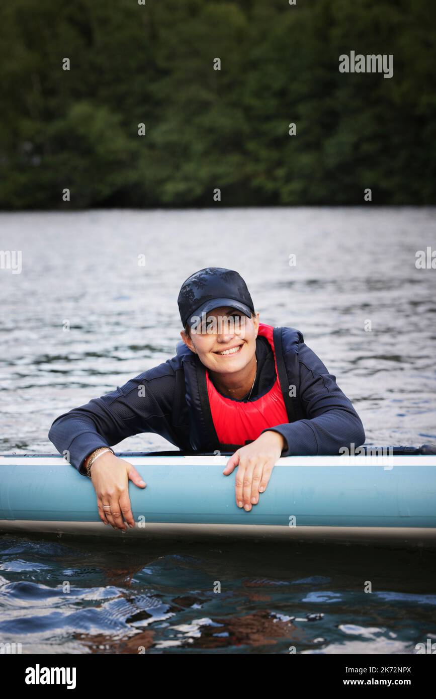 Porträt einer Frau, die auf dem See paddelt Stockfoto