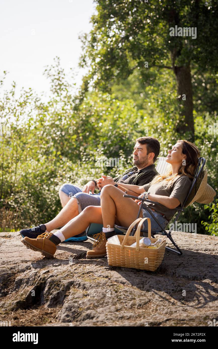 Pärchen sonnen sich auf Liegestühlen Stockfoto