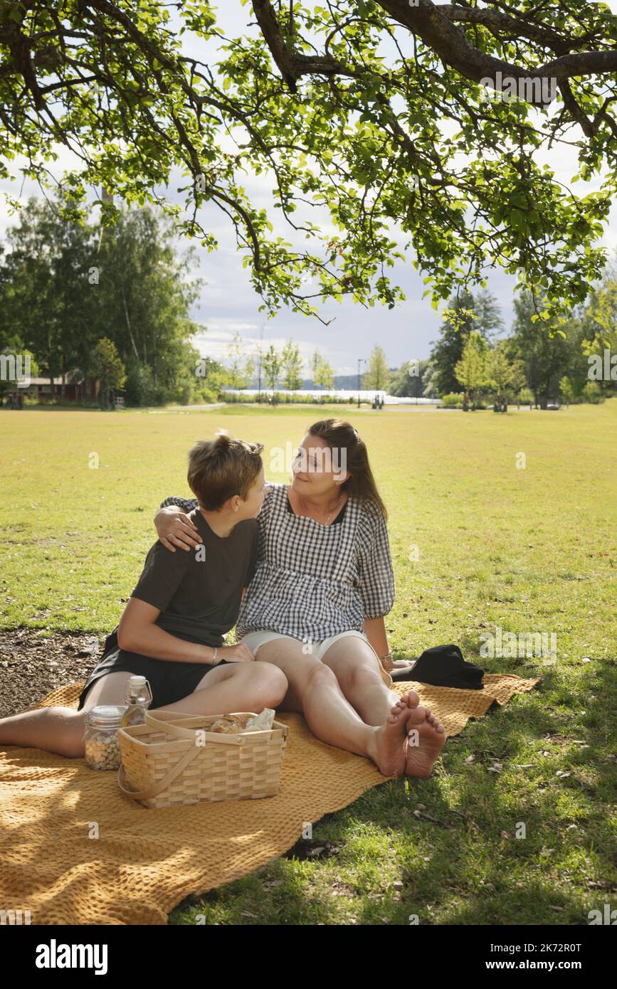 Mutter mit Sohn auf Picknickdecke sitzend Stockfoto