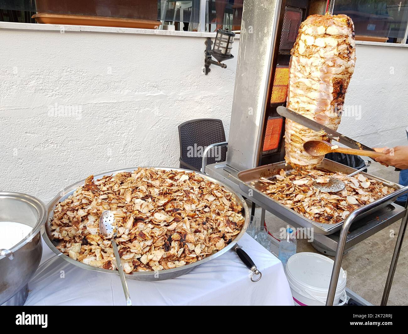 Ein Koch schneidet Hühnerfleisch auf einem Spieß, um Shawarma zu kochen. Traditionelles türkisches Essen Döner Kebab. Fast-Street-Food Stockfoto