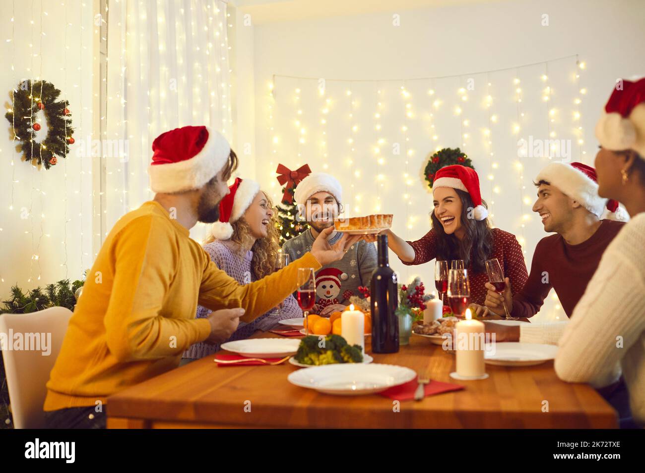 Lächelnde, multiethnische Freunde genießen zu Hause ein Weihnachtsessen Stockfoto