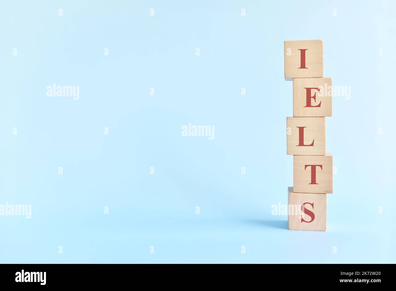 IELTS oder internationales prüfungssystem in englischer Sprache oder Prüfkonzept. Holzblöcke Typografie flach lag auf blauem Hintergrund. Stockfoto