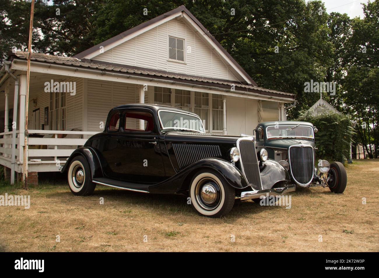 Zwei Ford Hot Rods im traditionellen Stil von 1934 vor einem Gebäude im Vintage-Stil. Stockfoto