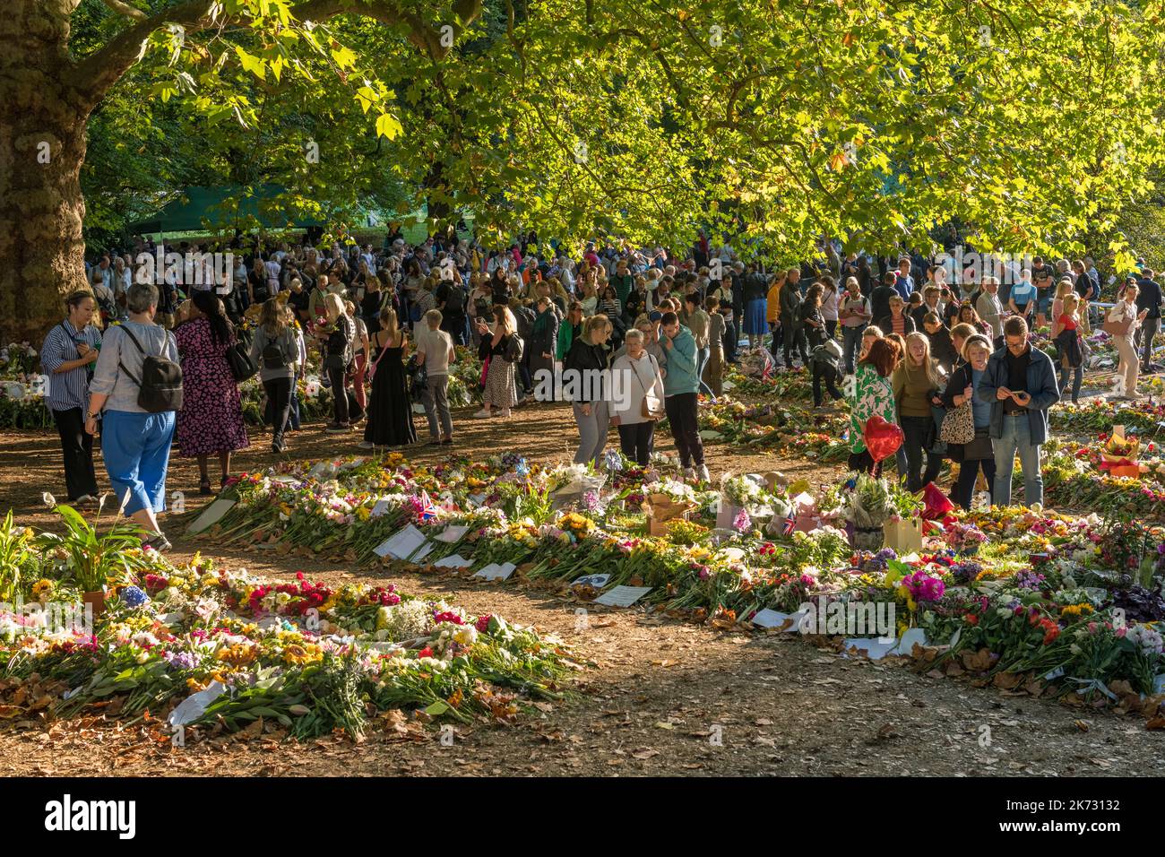 Große Menschenmengen versammeln sich im Green Park, London, Großbritannien, um die enorme Anzahl von Blumen und Blumengebeten zu sehen, die nach dem Tod von Königin Elizabeth II. Hinterlassen wurden Stockfoto