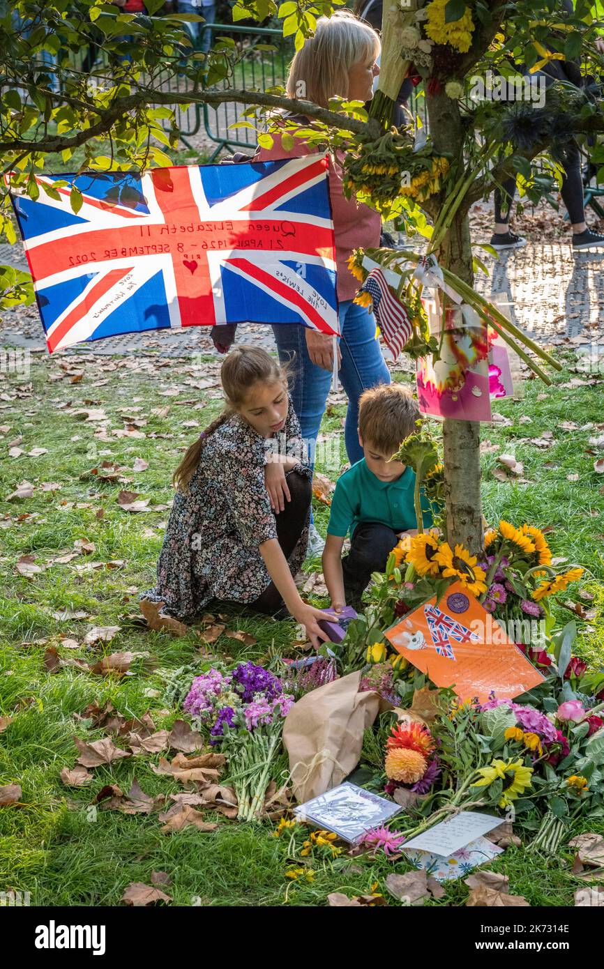 In Green Park, London, Großbritannien, inspizieren zwei Kinder die Tribute von Blumen und anderen Gegenständen, die nach dem Tod von Königin Elizabeth II. Hinterlassen wurden Stockfoto