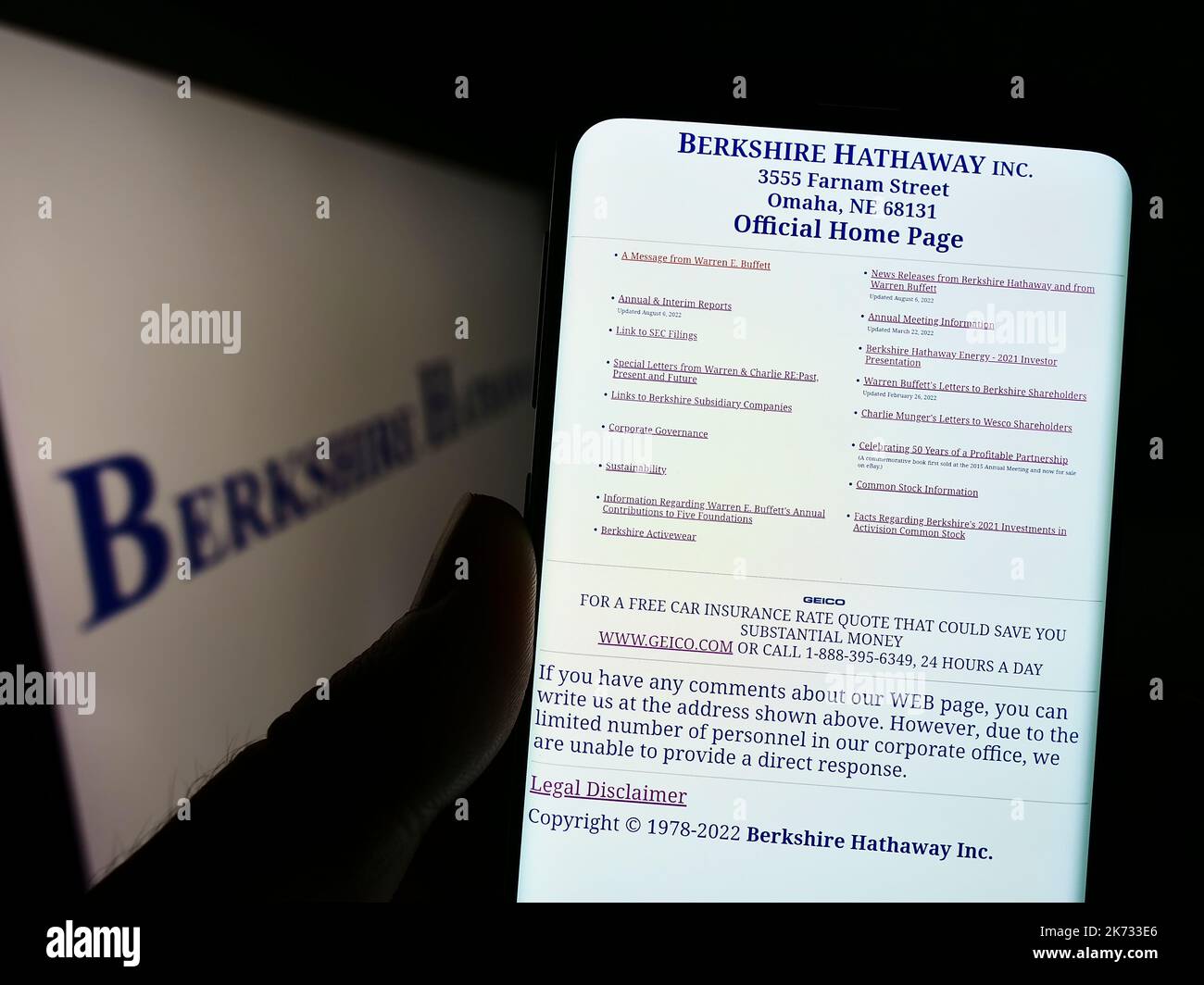 Person, die Mobiltelefon mit der Webseite der US-Holding-Gesellschaft, der Firma, der Firma, der Firma, auf dem Bildschirm vor dem Logo hält. Konzentrieren Sie sich auf die Mitte des Telefondisplays. Stockfoto