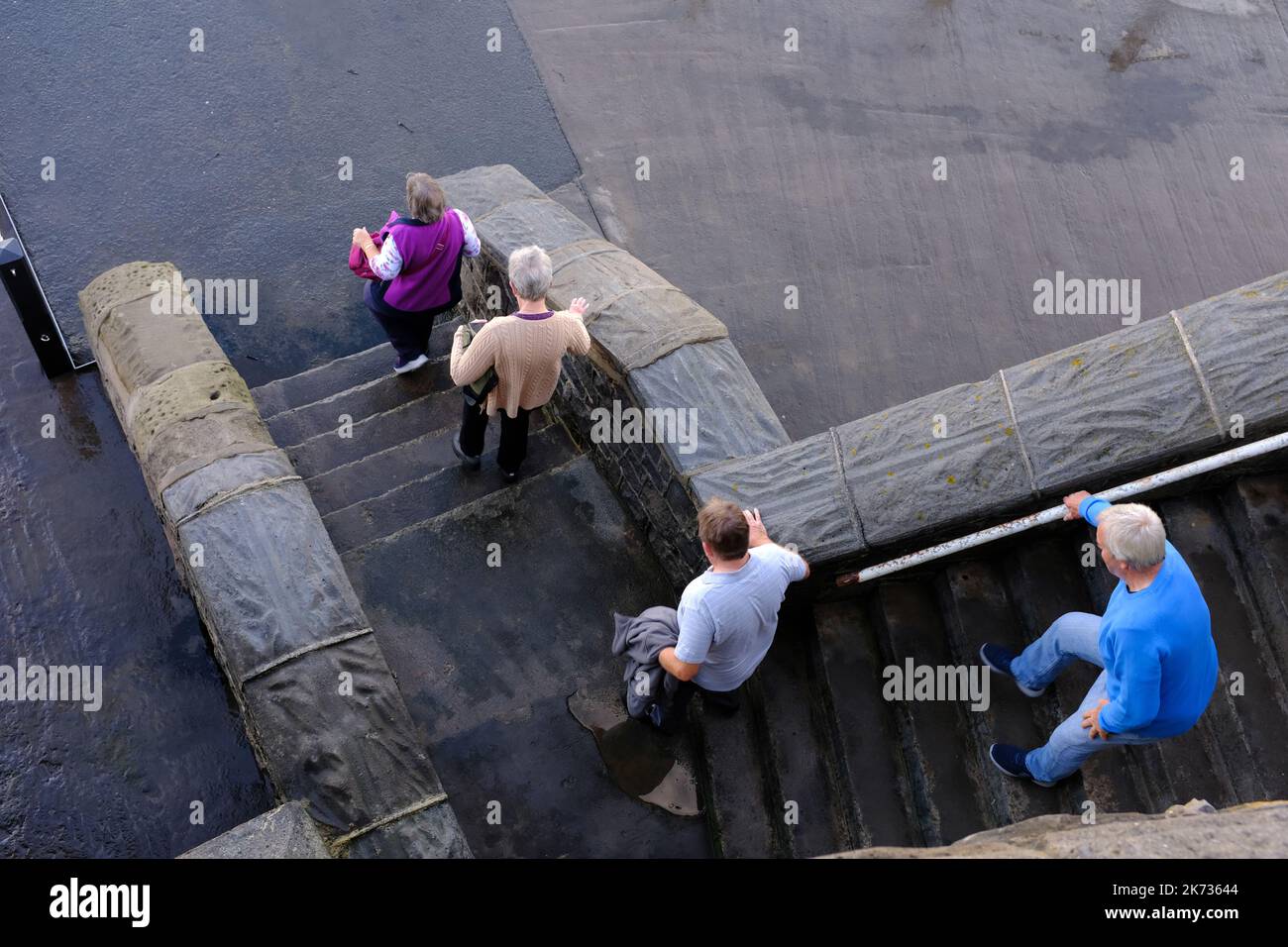 Ältere Leute, die rutschige Treppen hinunterlaufen, Stufen. Stockfoto