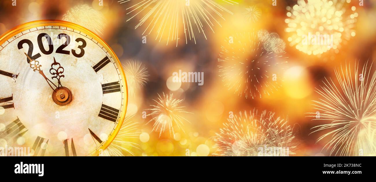 2023 Neujahr mit Feuerwerk und Uhr, die bis Mitternacht mit defokusserem goldenen Hintergrund zählt Stockfoto