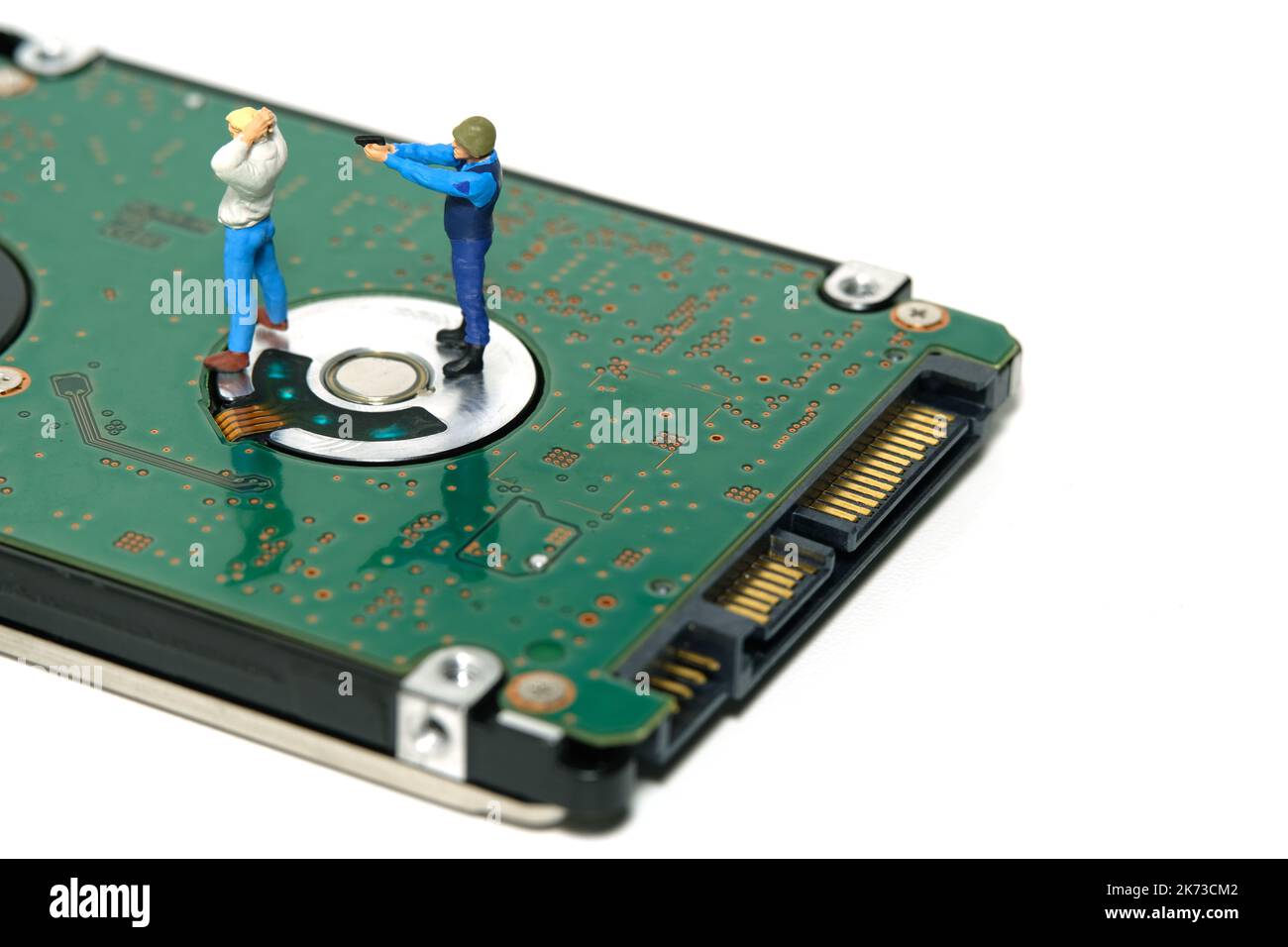 Miniatur Menschen Spielzeug Figur Fotografie. Datenschutzkonzept. Ein Sicherheitsbeauftragter erfasst einen Dieb über einem externen Festplattenlaufwerk. Isoliert auf weißem BA Stockfoto