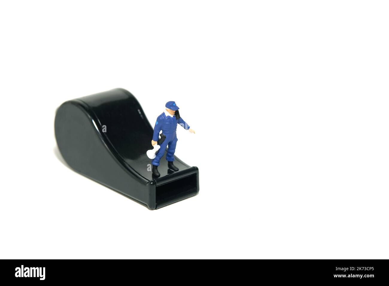 Miniatur Menschen Spielzeug Figur Fotografie. Konzept für den Schutz von JustizmitarbeiterInnen und WhistleblowerInnen. Ein Sicherheitsbeamter, der über einer schwarzen Pfeife steht. I Stockfoto