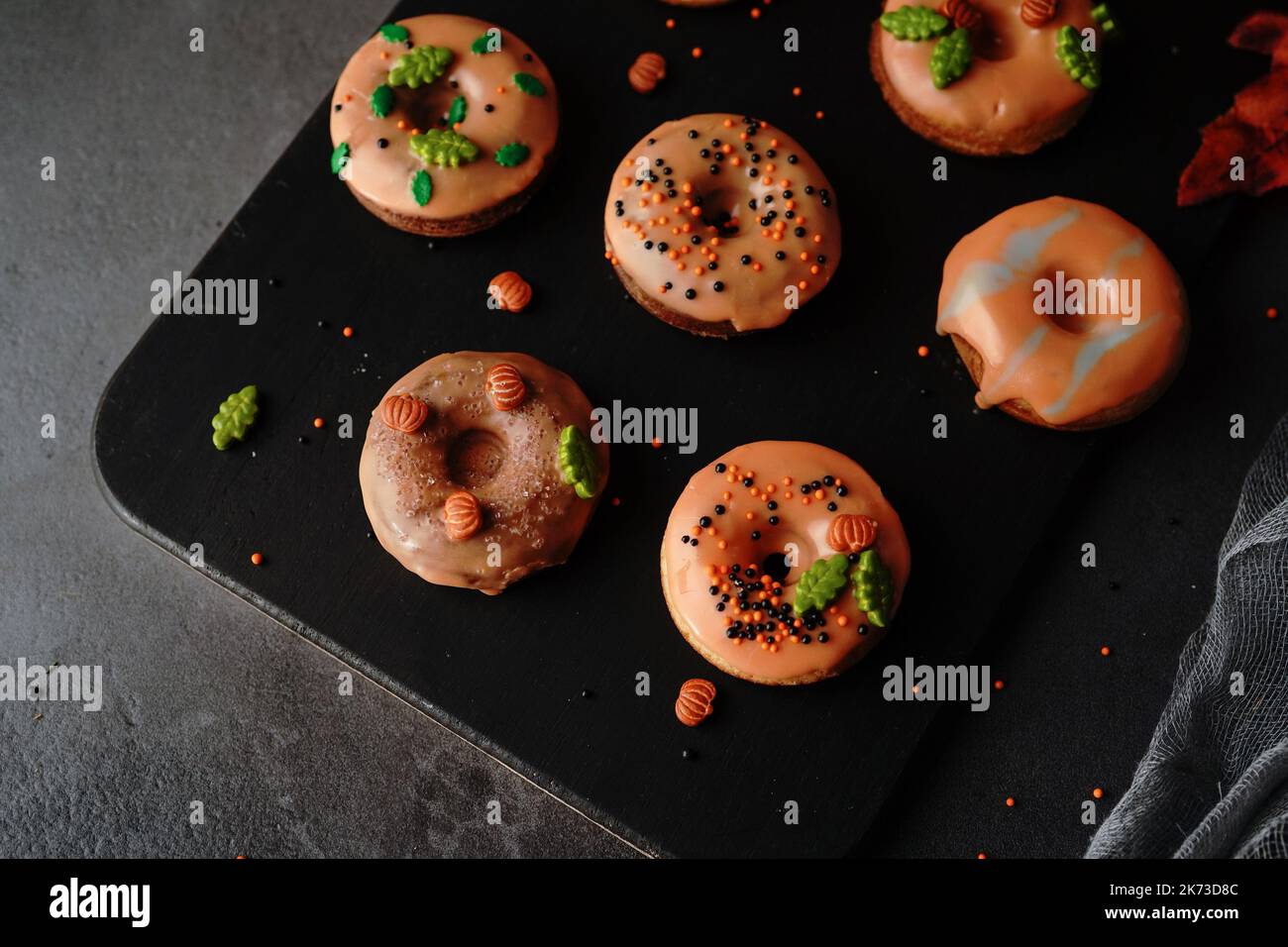 Hausgemachte Mini-Herbst-Donuts mit orangefarbenem Zuckerguss, selektivem Focu Stockfoto