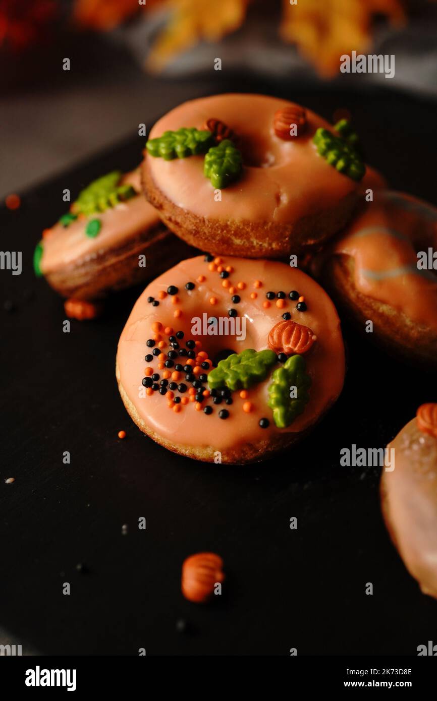 Hausgemachte Mini-Herbst-Donuts mit orangefarbenem Zuckerguss, selektivem Focu Stockfoto