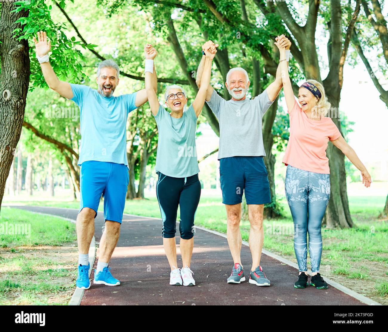 Outdoor Senior Fitness Frau Mann Lifestyle aktiver Sport Bewegung gesund fit Ruhestand Teamwork zusammen Hände haltend Stockfoto