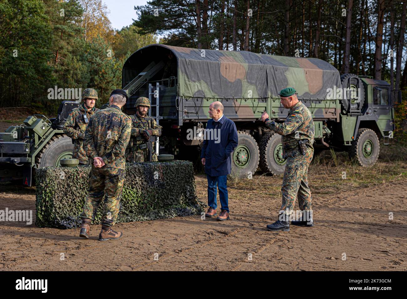 Ostenholz, Deutschland. 17. Oktober 2022. Bundeskanzler Olaf Scholz (SPD, 2. von rechts) lässt sich vor der aus- und Einweisung der Bundeswehr im Heidekreis Lüneburger Heide Geräte der Bundeswehr erklären. Quelle: Moritz Frankenberg/dpa/Alamy Live News Stockfoto