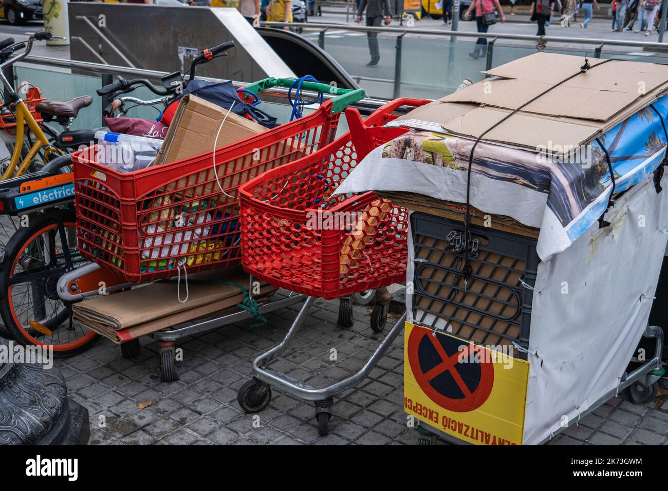 Barcelona, Spanien. 17. Oktober 2022. Drei Supermarktwagen, die von Obdachlosen benutzt werden, sind voller Objekte, die auf der Plaza de Catalunya geparkt sind. Anzeichen von Betteln und Armut in Barcelona am Internationalen Tag zur Beseitigung der Armut, der von den Vereinten Nationen seit 1992 anerkannt wird. (Foto von Paco Freire/SOPA Images/Sipa USA) Quelle: SIPA USA/Alamy Live News Stockfoto