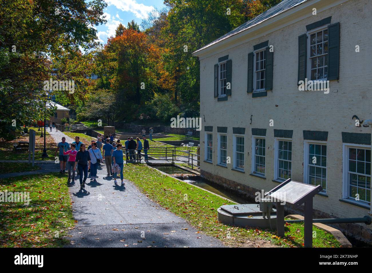 USA West Virginia WV Berkeley Springs Herbst Morgan County Appalachian Mountains Menschen, die am Museum und der alten Mühle vorbeilaufen Stockfoto