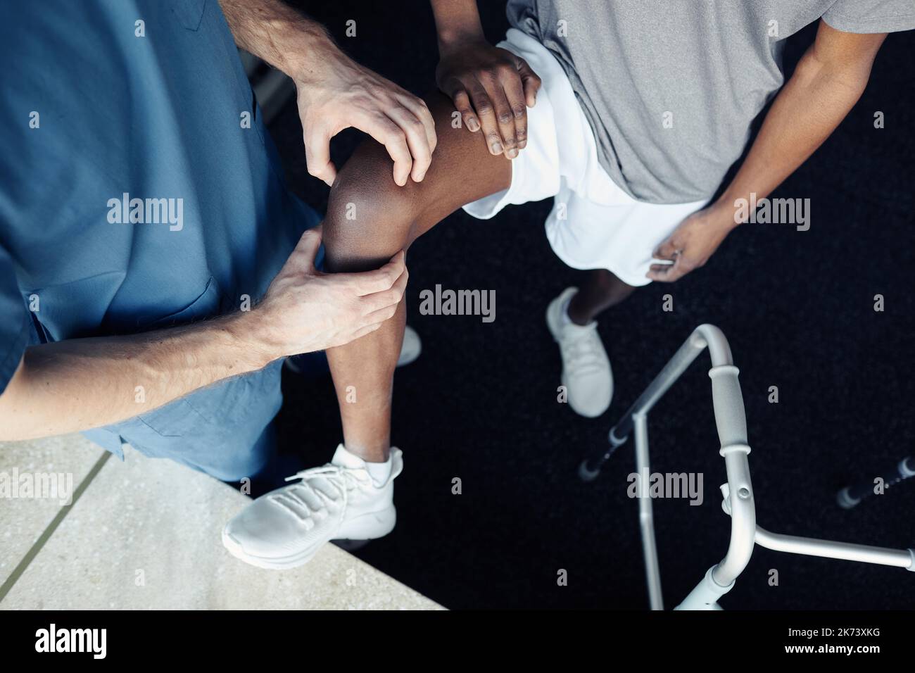 Aus der Sicht eines männlichen Arztes, der das Bein des Patienten während des Trainings im Fitnessstudio massiert Stockfoto