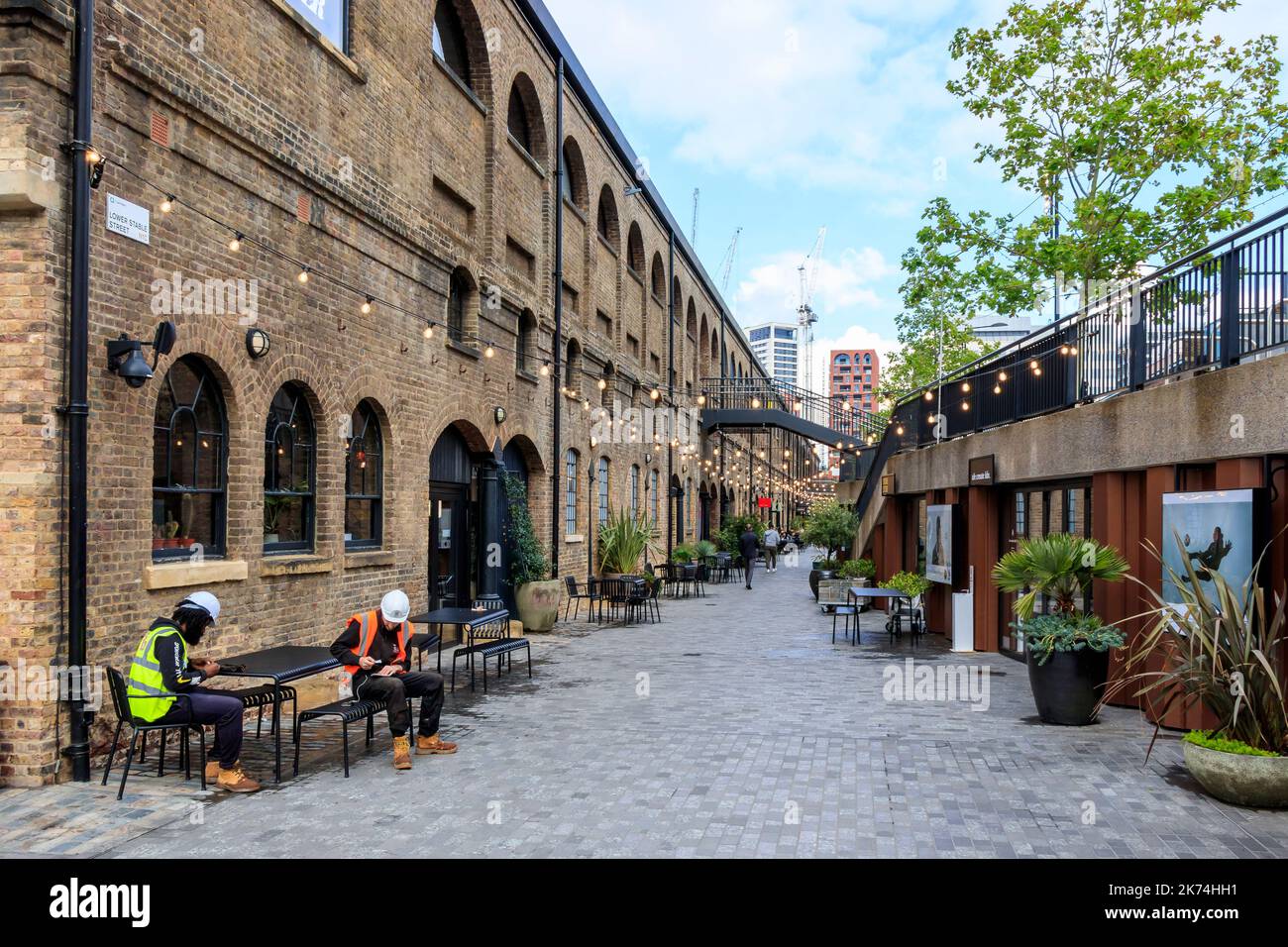 Arbeiter, die eine Pause vor einer Bar in der Lower Stable Street im Reentwicklungsgebiet King's Cross, London, Großbritannien, einlegen Stockfoto