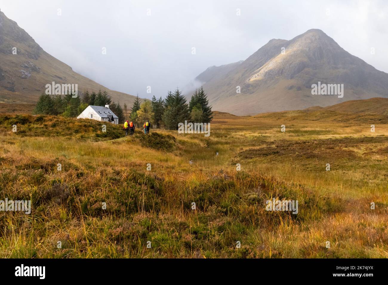 Gruppe von Wanderern nähert sich Lagangarbh Hut am Beginn des Buachaille Etive Mor Walk vom Parkplatz Altnafeadh im Herbst, Glen Coe, Schottland, Großbritannien Stockfoto