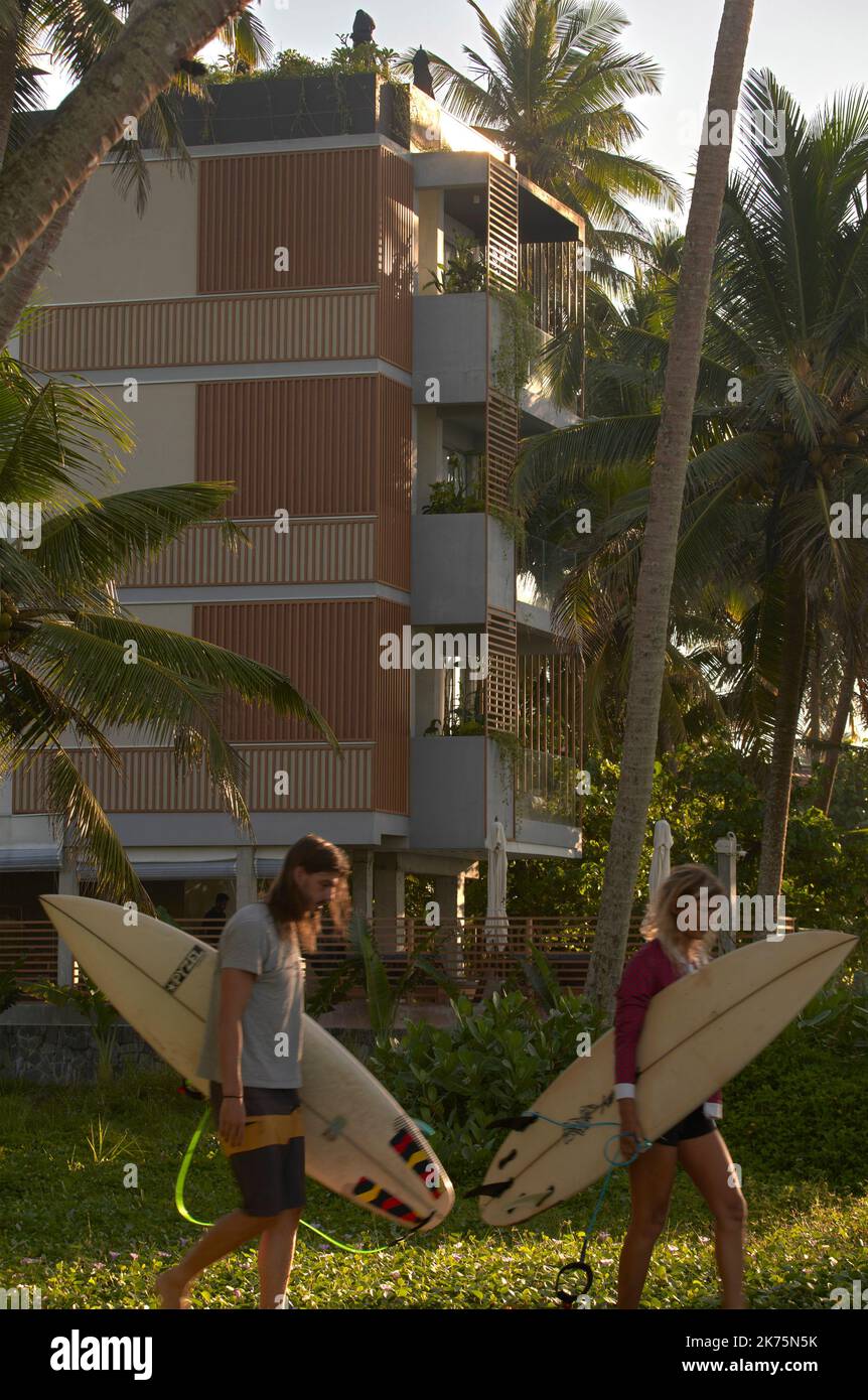 Surfer, die im Morgengrauen am Hotel vorbeikommen. Harding Boutique Hotel, Ahangama, Sri Lanka. Architekt: ANARCHITECT , 2021. Stockfoto
