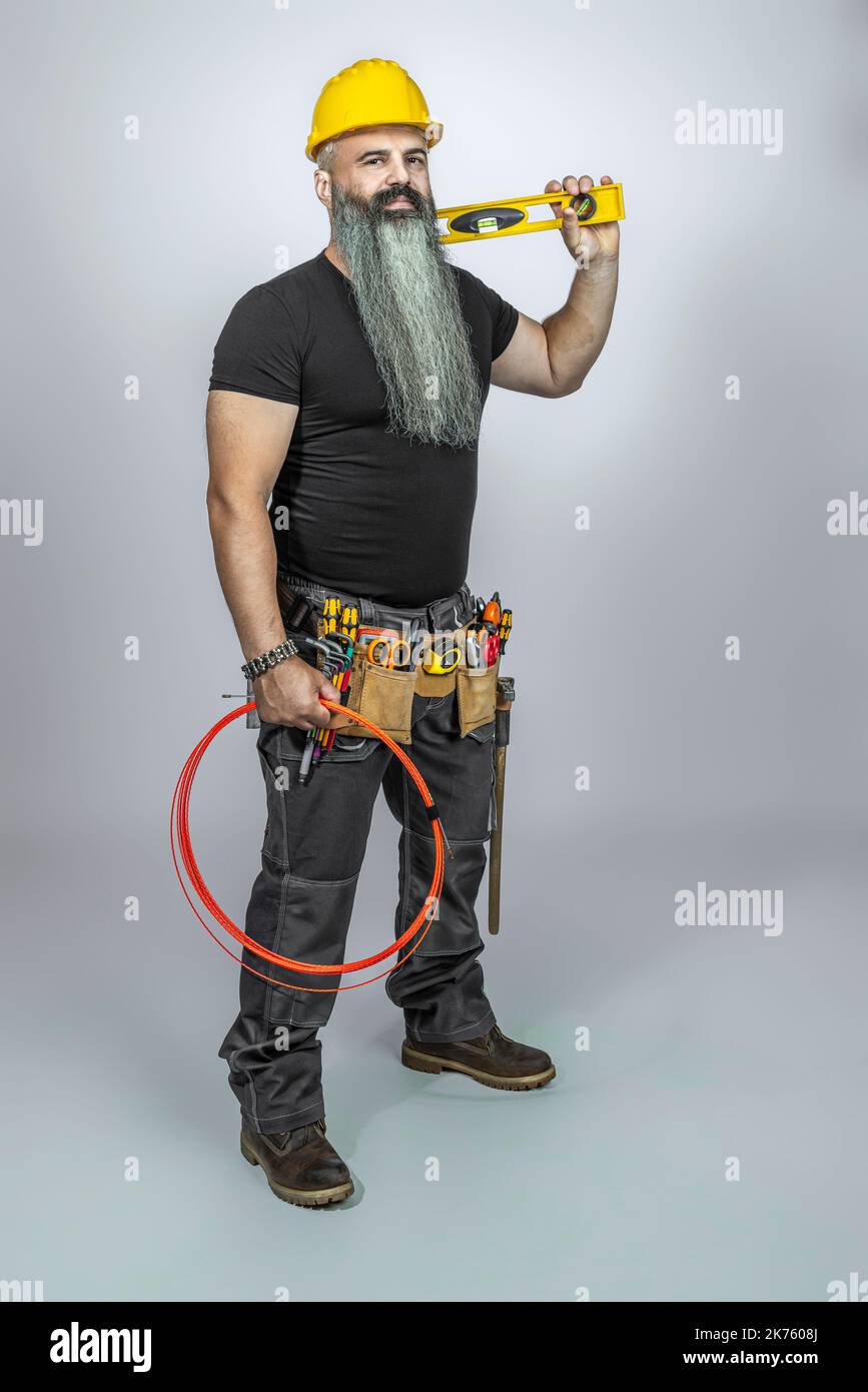 Elektriker mit langem Bart auf grauem Hintergrund Stockfoto