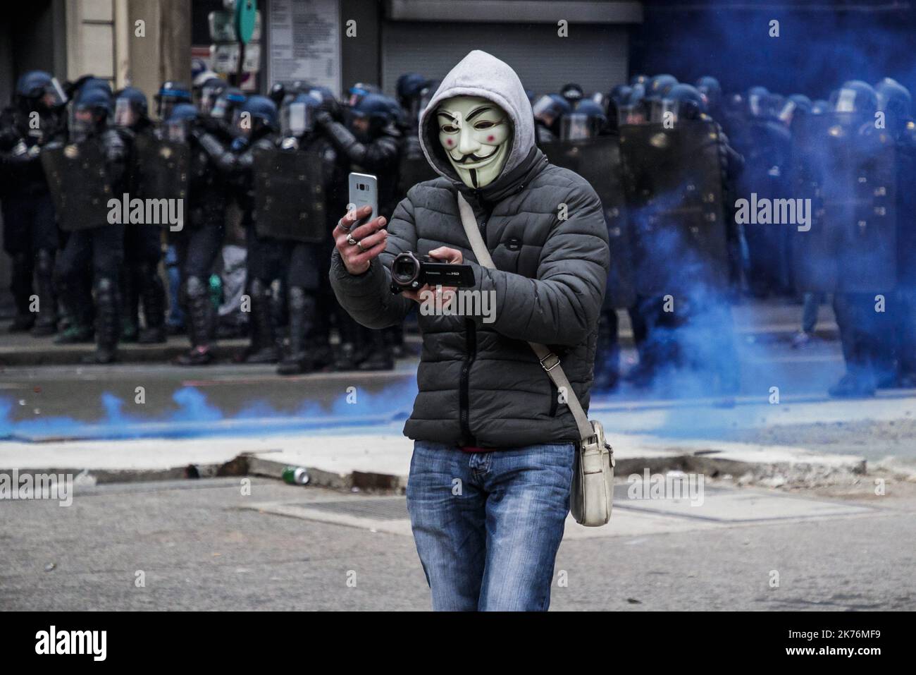 ©Christophe Petit Tesson/MAXPPP - 15/12/2018 ; PARIS ; FRANKREICH - UN manifest portant un masque de Guy Fawkes se filme lors d'affrontements avec des membres de forces de Police lors de l'Acte V du mouvement de protestation contre l'augmentation des taxes sur le carburant. Ein Mann mit einer Maske filmt die Polizeikräfte während einer Demonstration in Paris, Frankreich, am 15. Dezember 2018. Die sogenannten "Gilets Jaunes" (Gelbwesten) sind eine Protestbewegung, die angeblich keine politische Zugehörigkeit hat, die landesweit die Proteste über hohe Kraftstoffpreise fortsetzt. Stockfoto