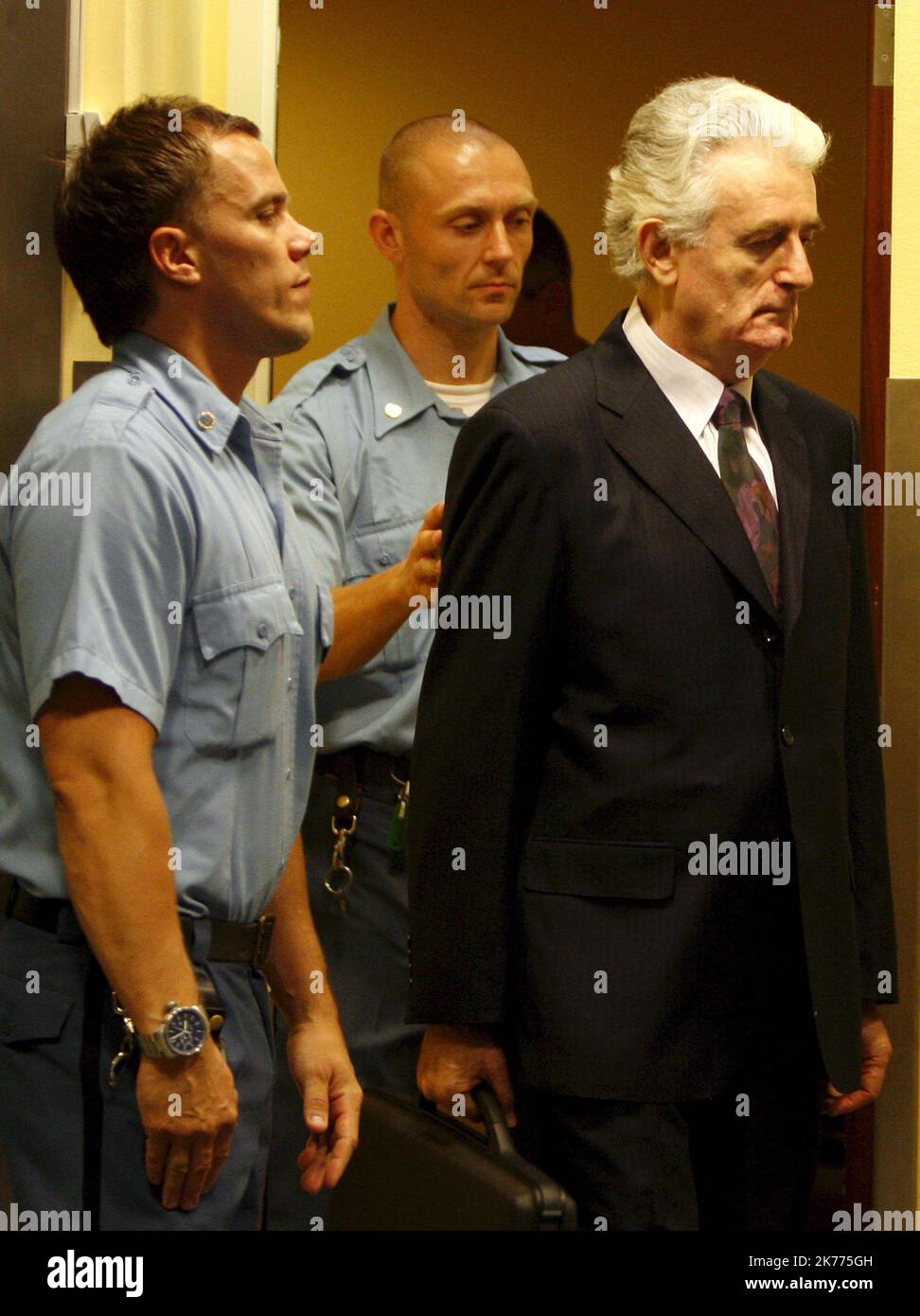 Der ehemalige bosnisch-serbische Führer Radovan Karadzic (R) tritt zu Beginn seines ersten Auftritts in Den Haag, Niederlande, am 31. Juli 2008 in den Gerichtssaal des Internationalen Strafgerichtshofs für das ehemalige Jugoslawien ein. Karadzic steht zum ersten Mal einem UN-Kriegsverbrecher gegenüber, der wegen Völkermordes für seine Handlungen im Bosnien-Krieg von 1992-95 angeklagt wurde. Stockfoto