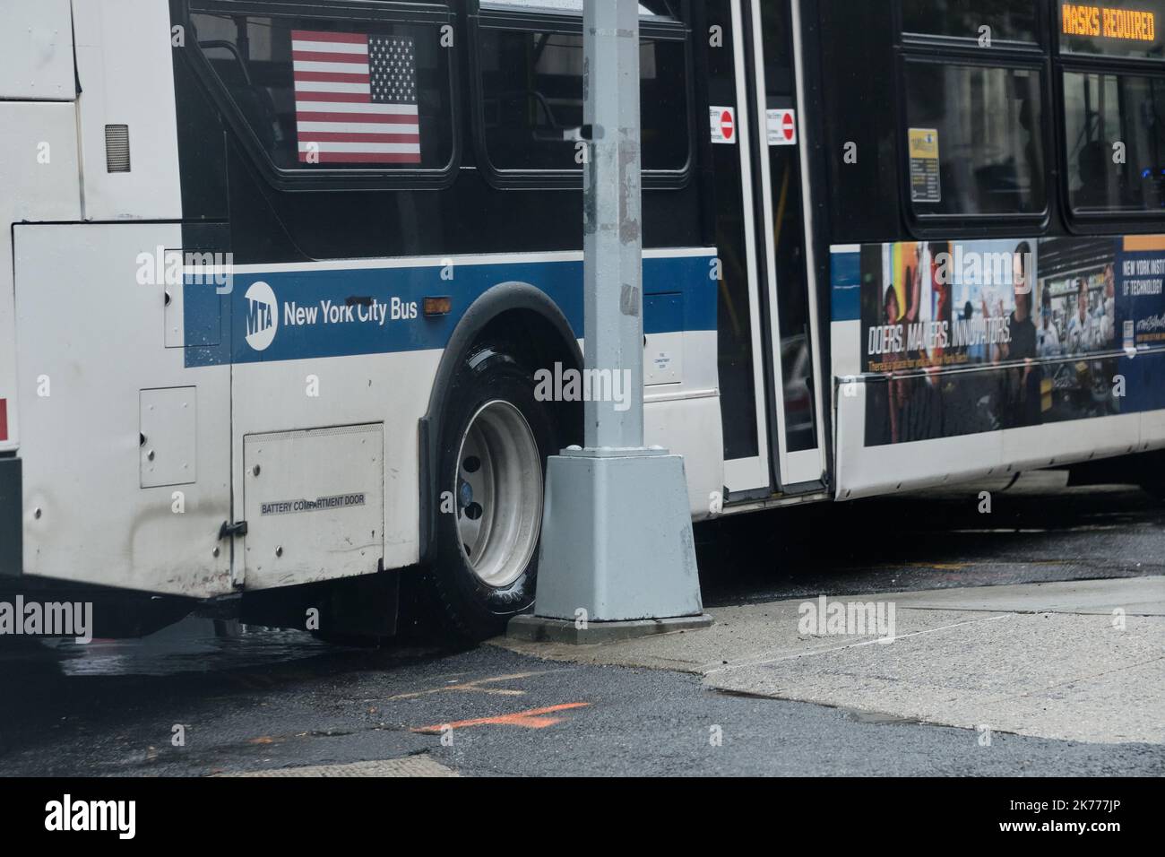 Der NYC MTA-Bus verpasst in einer engen Kurve fast den Lichtmast Stockfoto