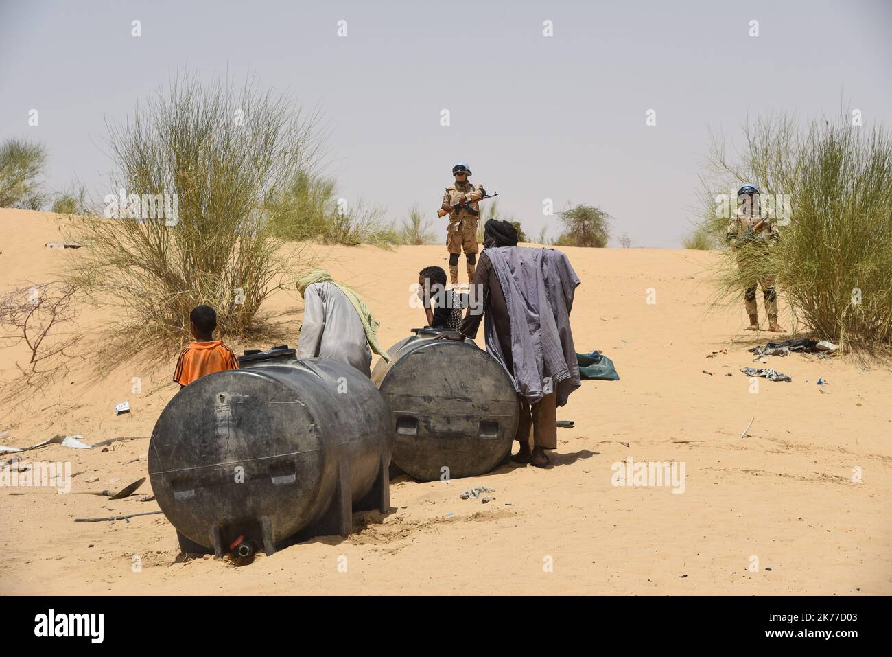 Dorfbewohner aus Koygouma (Kreis Goundam, Gemeinde Gargando) in der Region Timbuktu kommen, um Wasser aus einer Zisterne zu holen. Nach Angaben einiger Bewohner würden die Tanks in Goundam etwa 50km von Koygouma aus gefüllt werden, bevor sie in das Dorf transportiert werden. Der Zugang zu Trinkwasser ist heute eines der wichtigsten Probleme für die Bevölkerung dieser Wüstengebiete, die mit einer erheblichen Wasserknappheit konfrontiert sind, während im vergangenen April 2086 malische Flüchtlinge aus dem Mbera-Lager in Mauretanien in ihr Dorf zurückgeführt wurden. Stockfoto