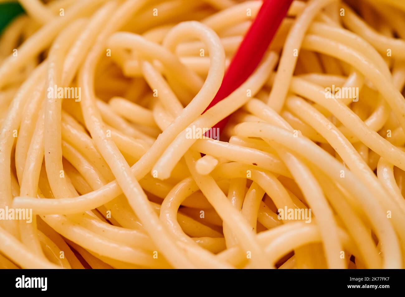 Bio-Grieß-Pasta wird in einer kleinen Schale mit roten Chapsticks über einem roten Küchetücher serviert Stockfoto