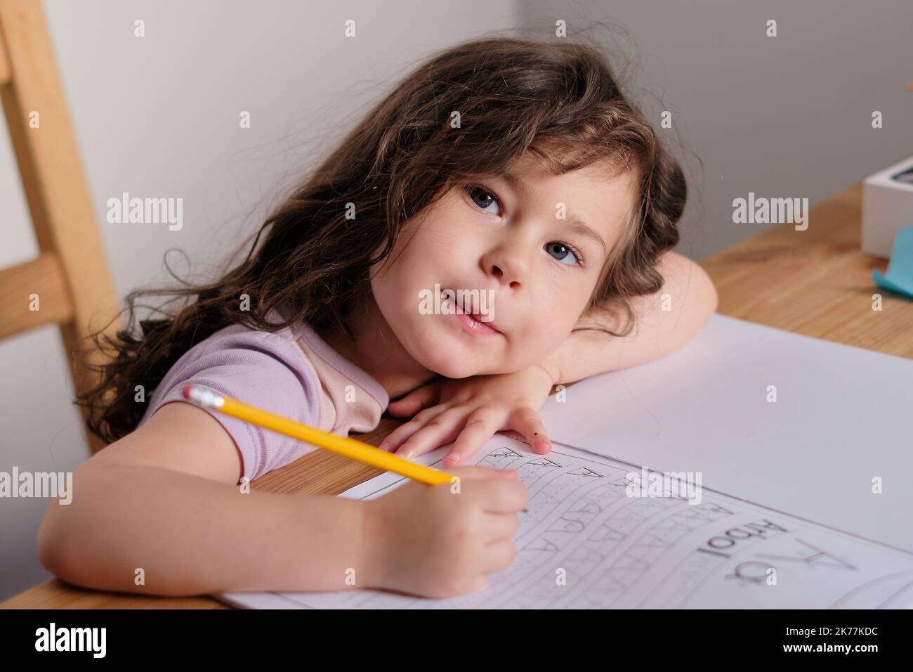 Young Pretty ist ein Mädchen, das Buchstaben in einem Buch verfolgt Stockfoto