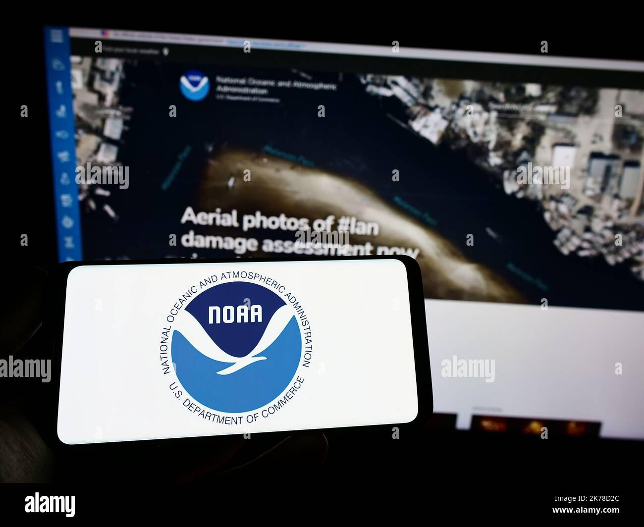 Person, die das Smartphone mit dem Logo der National Oceanic and Atmospheric Administration (NOAA) auf dem Bildschirm mit einer Webseite hält. Konzentrieren Sie sich auf die Telefonanzeige. Stockfoto