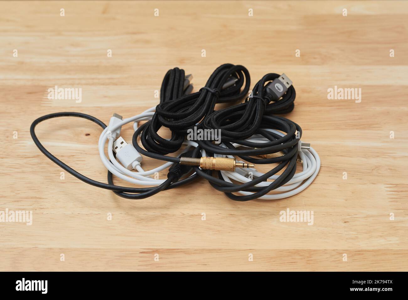 Auf einem Arbeitstisch liegende Elektro- und Ladekabel verschiedener Art Stockfoto