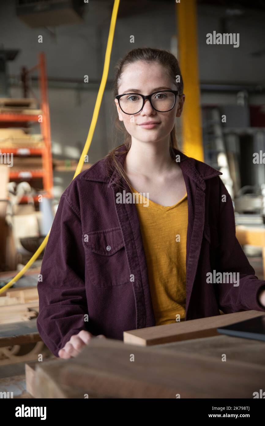 Porträt einer Schülerin in einer Werkstatt, die in die Kamera schaut Stockfoto