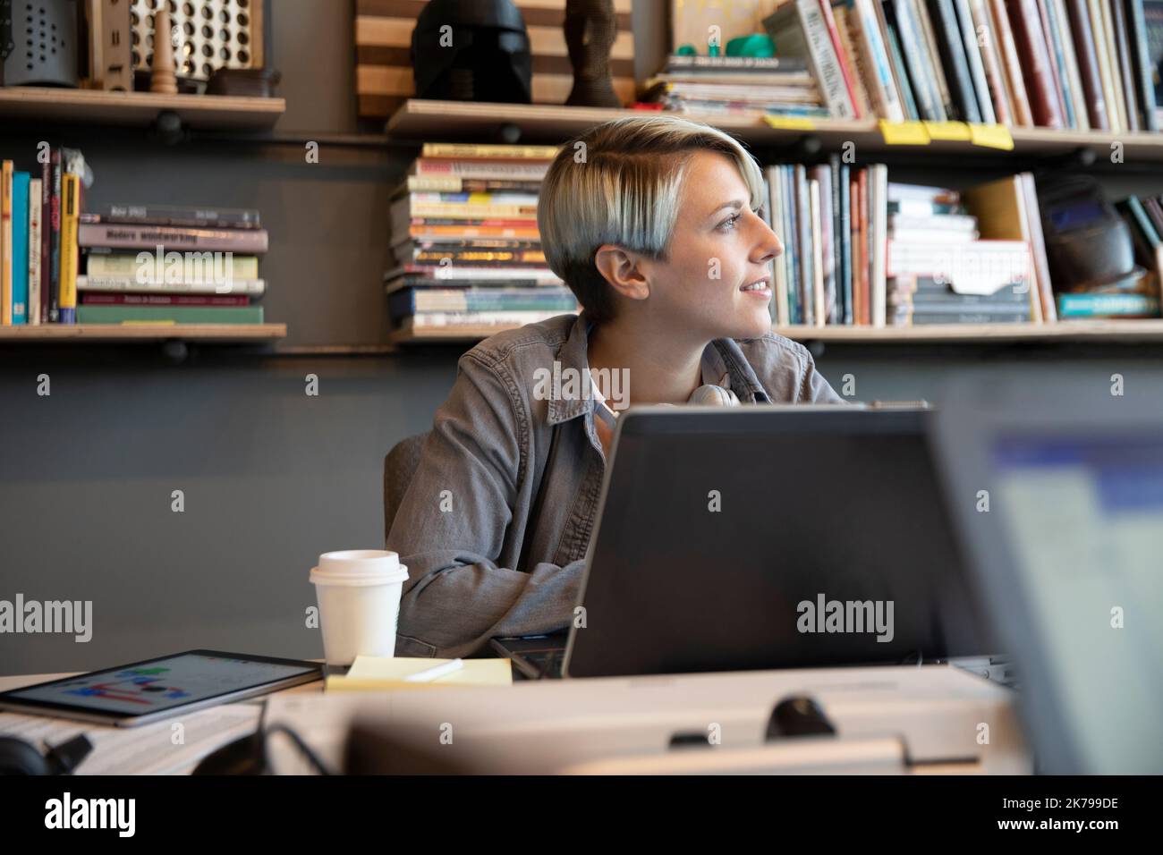 Junge Frau mit kurzen Haaren, die in einem kreativen Büro arbeitet Stockfoto