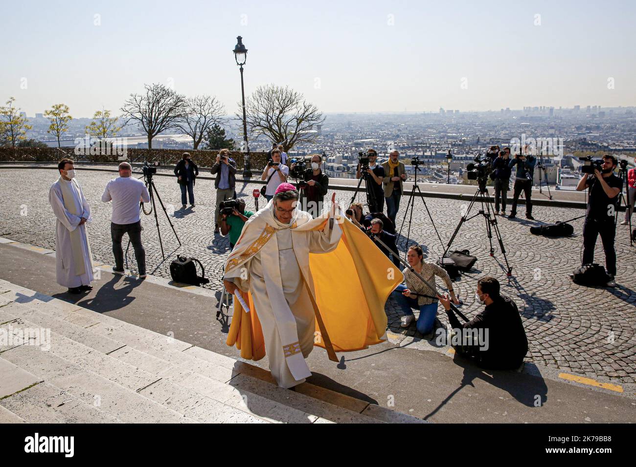 Journalisten stehen um den Erzbischof von Paris Michel Aupetit herum, als er die französische Hauptstadt von der Basilika Sacre-Coeur in Montmartre in Paris segnet, während er während einer Sperre, die die Ausbreitung der Coronavirus-Krankheit (COVID-19) in Frankreich verlangsamen soll, die Osterfeierlichkeiten abhielt. Paris, 09.04.2020 Stockfoto