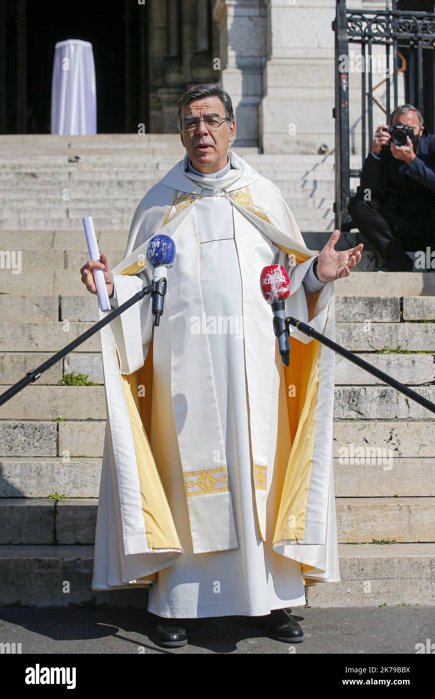 Journalisten stehen um den Erzbischof von Paris Michel Aupetit herum, als er die französische Hauptstadt von der Basilika Sacre-Coeur in Montmartre in Paris segnet, während er während einer Sperre, die die Ausbreitung der Coronavirus-Krankheit (COVID-19) in Frankreich verlangsamen soll, die Osterfeierlichkeiten abhielt. Paris, 09.04.2020 Stockfoto