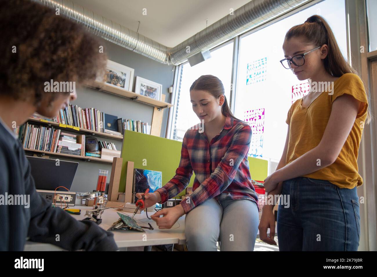 Drei Studenten verwenden Lötgeräte in einer Technikwerkstatt Stockfoto