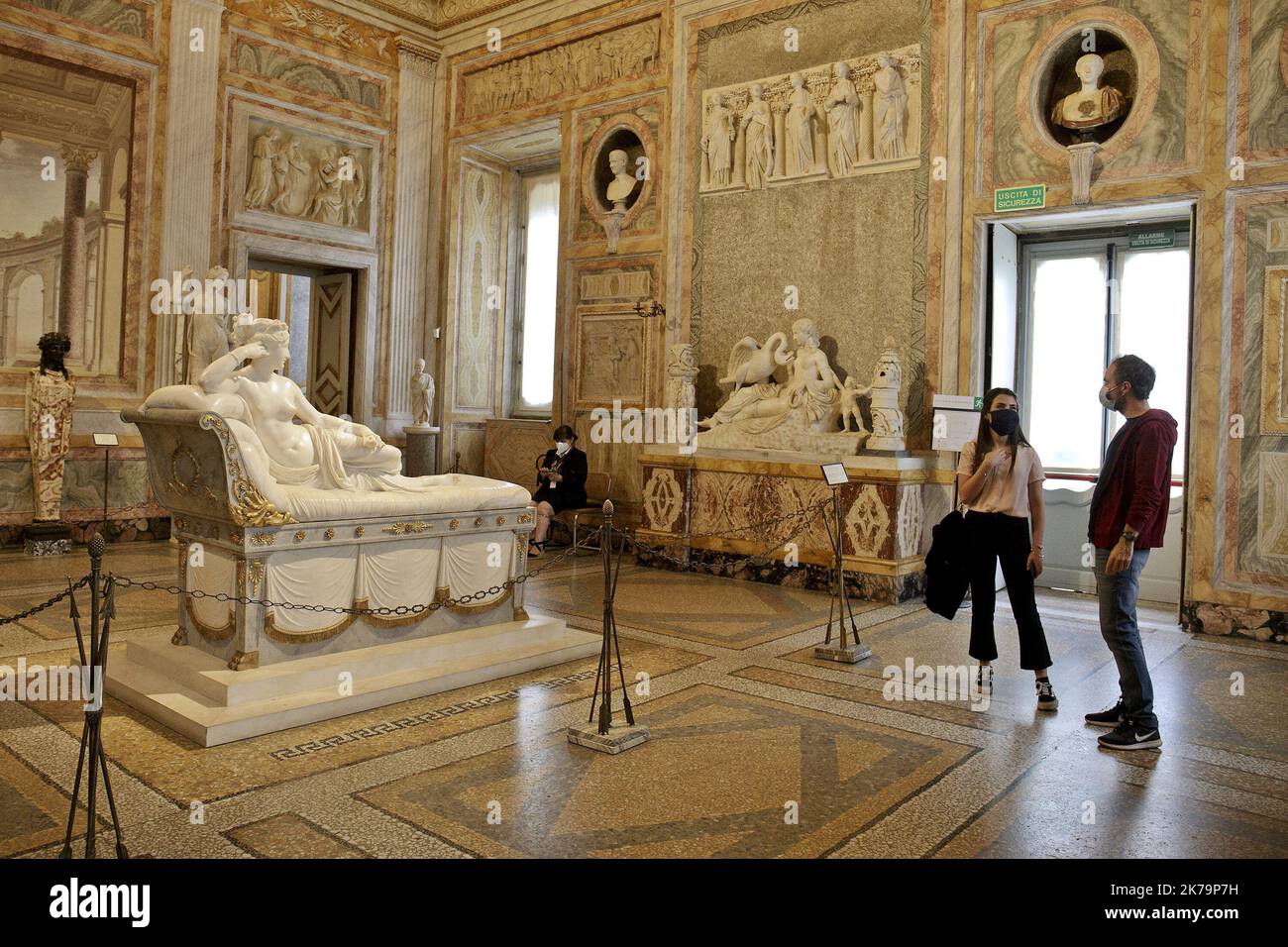 Besucher, die eine Gesichtsmaske tragen, sehen der Paolina Borghese Bonaparte als Venus Victrix, eine Marmorskulptur aus dem Jahr 1805-1808 von Antonio Canova in der Galleria Borghese in Rom am 20. Mai 2020, als sie nach einer zweimonatigen Sperre, die die Ausbreitung der COVID-19-Infektion eindämmen soll, wieder eröffnet wird, Verursacht durch das neuartige Coronavirus. Stockfoto