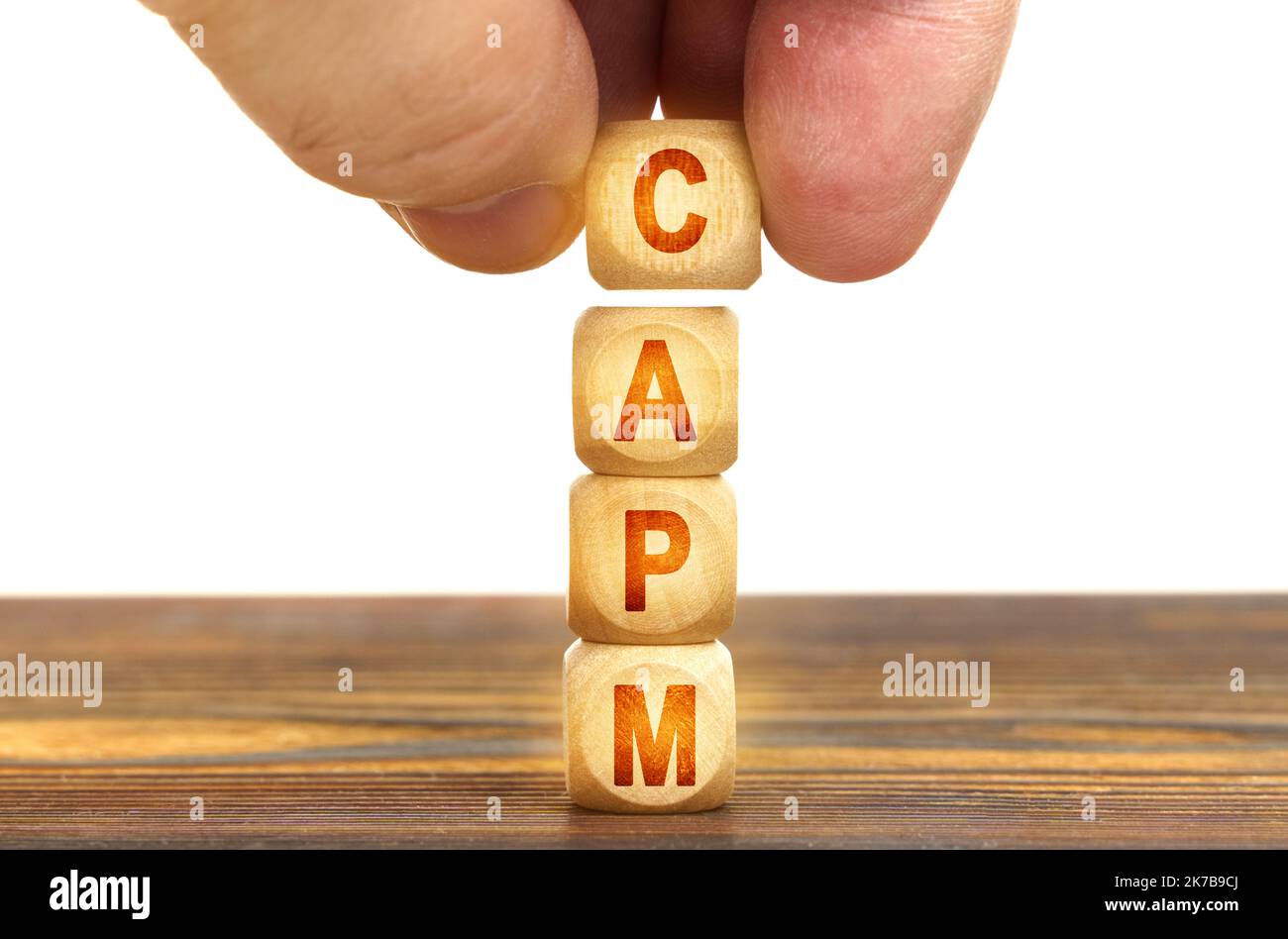 Geschäftskonzept. Ein Mann legt Holzwürfel mit der Aufschrift CAPM auf den Tisch Stockfoto