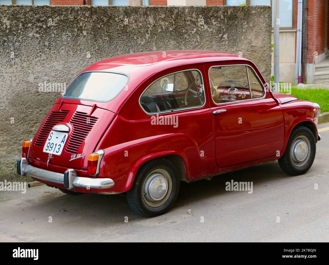 Rückansicht eines roten Seat 600e, der in einer Seitenstraße von Llanes Asturias Spanien geparkt ist Stockfoto