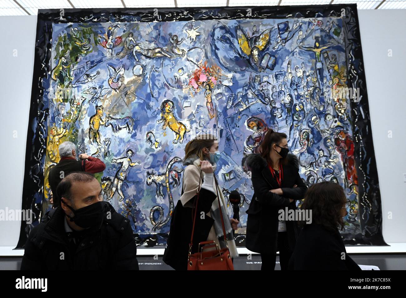 ©PHOTOPQR/L'EST REPUBLICAIN/ALEXANDRE MARCHI ; METZ ; 11/12/2020 ; KULTUR - AUSSTELLUNG MARC CHAGALL PASSEUR DE LUMIERE - MUSEE - PEINTURES - DESSINS - COLLAGEN - VITRAUX - SIGNATURE - AUTOGRAPHE. Centre Pompido-Metz 11 Décembre 2020. Des personnes portant des masques de Protection devant la tapisserie de basse lisse, laine et coton 'La Paix' (1991-1994) d'Yvette CAUQUIL-PRINCE d'après Marc Chagall dans l'Exposition inédite 'Chagall. Passeur de Lumière' sur 1200 m² en galerie 3 du Centre Pompiu-Metz jusqu'au 26 avril 2021. FOTO Alexandre MARCHI. - Metz, Frankreich, dezember 11. 2020 - Ausstellung Stockfoto