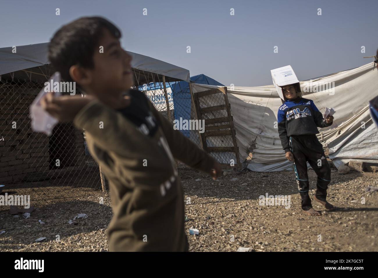 ©Christophe Petit Tesson/MAXPPP - 26/11/2021 ; HASSAN SHAM ; IRAQ - UN enfant lance un avion en Papier au 'Camp U3' a Hassan Sham, a 30 km a l'est de Mossoul, le Camp est Surveillance commune des autorites kurde et Irakienne. UN espace de ce Camp de refugies est Reserve aux anciens mineurs combattant de l'Etat Islamique, non condamne par la Justice ils n'ont pas le droit de sortir du Camp . U3 Lager in Hassan Sham. Dieses Flüchtlingslager 30 km östlich von Mosul wird von den kurdischen Behörden verwaltet. Eine Zone im Lager ist ehemaligen jungen Kämpfern des Islamischen Staates vorbehalten, die nicht von Jcourt verurteilt werden Stockfoto