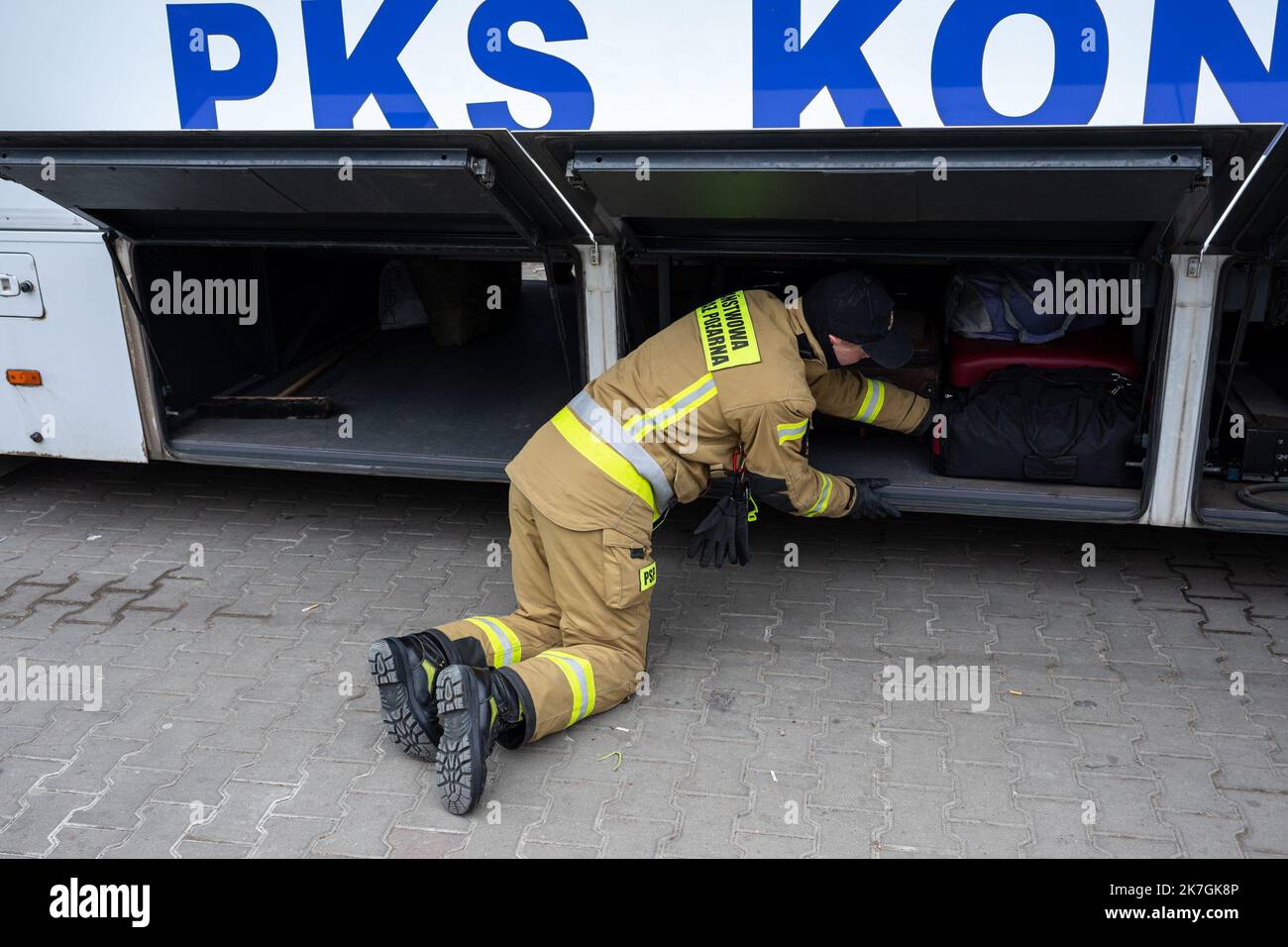 ©Simon Becker / Le Pictorium/MAXPPP - Korczowa 06/03/2022 Simon Becker / Le Pictorium - 6/3/2022 - Pologne / Jaroslaw / Korczowa - UN membre du Service national des pompiers polonais aide a deballer les bagages d'un Bus qui vient d'arriver au Centre Commercial Korczowa Dolina, Qui sert de Point d'accueil Massiv pour les personnes fuyant la guerre en Ukraine. / 6/3/2022 - Polen / Jaroslaw / Korczowa - Ein Mitglied der polnischen Staatlichen Feuerwehr hilft beim Auspacken des Gepäcks aus einem Bus, der gerade in der Korczowa Dolina Mall angekommen ist, die als massiver Empfangsort für Menschen dient, die vor dem Krieg in Ukr fliehen Stockfoto