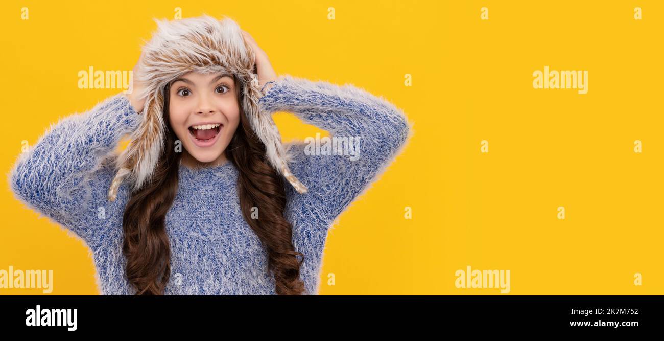 Weibliche Mode-Modell. Teen Mädchen in Strickmode auf gelbem Hintergrund. Banner des Kindes Mädchen im Winterhut, Studio Poster Header mit Copy Space. Stockfoto