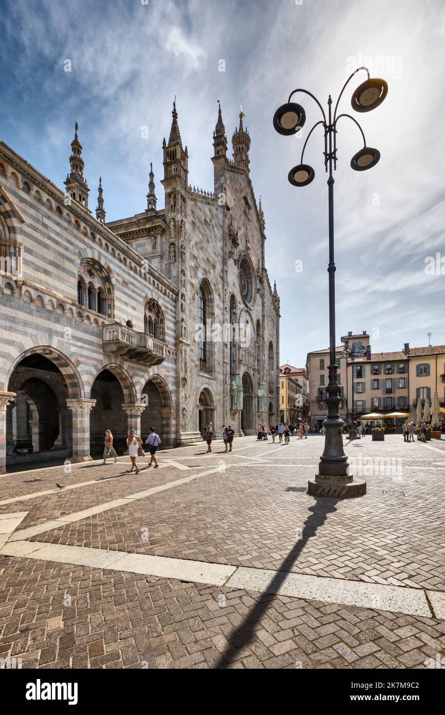 Hauptfassade der Kathedrale im gotischen Stil an einem sonnigen Tag. Menschen überqueren die Piazza del Duomo vor sich. Bild mit hohem Dynamikbereich. Stockfoto