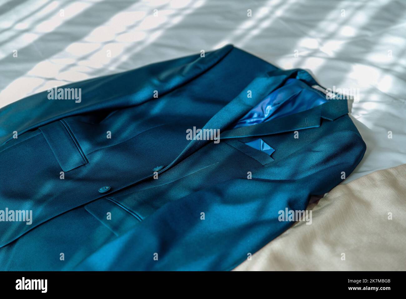 Stilvoller, eleganter Hochzeitsanzug mit Aufhängung im Hotelapartment. Hochzeitszubehör für den Bräutigam. Stockfoto