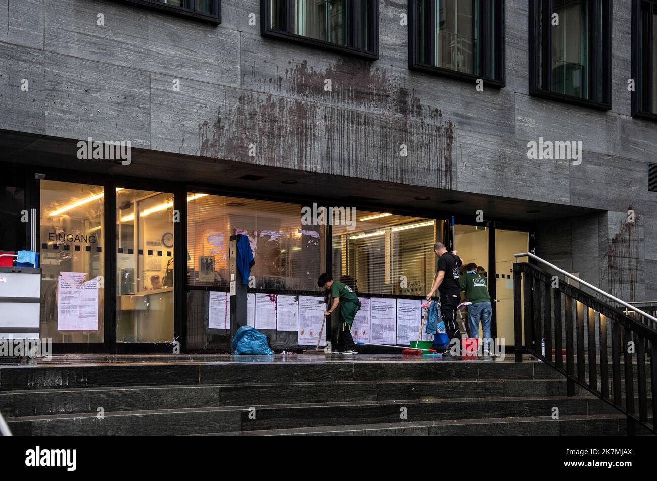 18. Oktober 2022, Berlin: Reinigungskräfte entfernen Transparente des Bundesverkehrsministeriums, die Klimaaktivisten der Umweltschutzgruppe Scientist Rebellion bei einer Protestaktion zuvor an der Wand befestigt hatten. Zudem hatten die Aktivisten die Fassade mit roter Farbe beschmiert. Die Polizei war mit einem großen Kontingent vor Ort und nahm die persönlichen Daten der Aktivisten mit. Foto: Paul Zinken/dpa Stockfoto