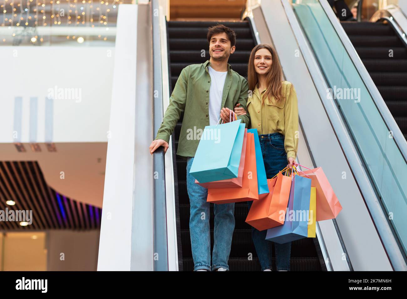 Paar Hält Taschen Einkaufen Stehen Auf Beweglichen Treppen In Der Mall Stockfoto