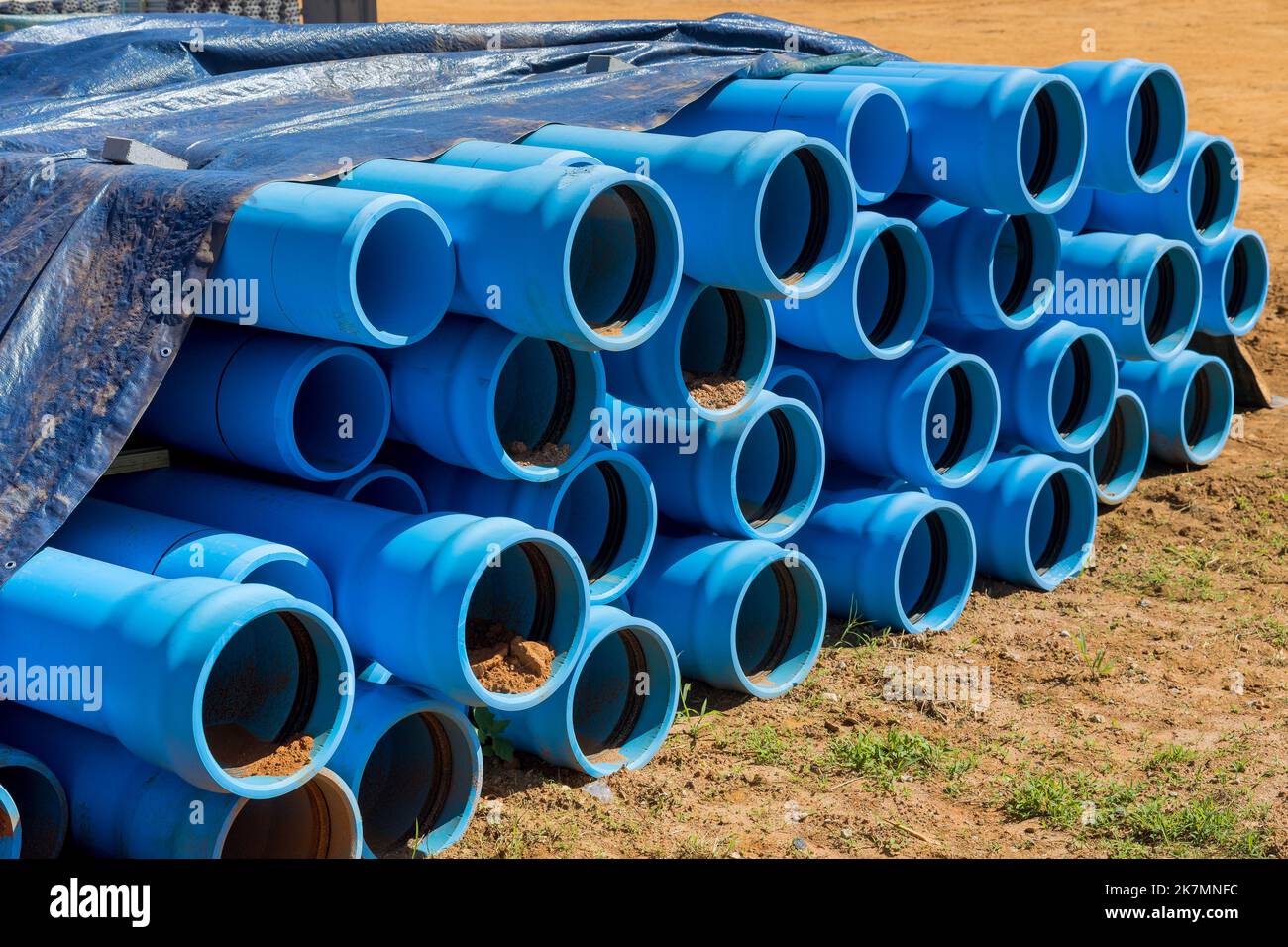 Auf der Baustelle für zu Hause werden blaue Kunststoffrohre aus PVS in das Abflussseptiksystem eingeführt, das installiert wird Stockfoto